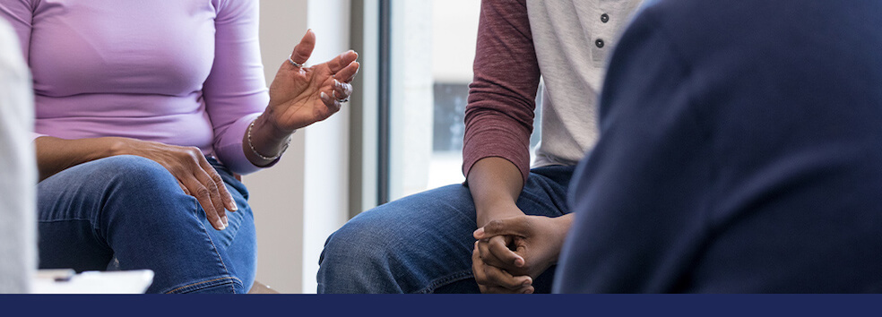 Three people sit in a circle talking