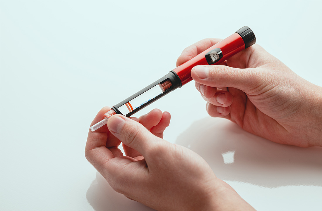 Hands holding diabetic insulin pen.