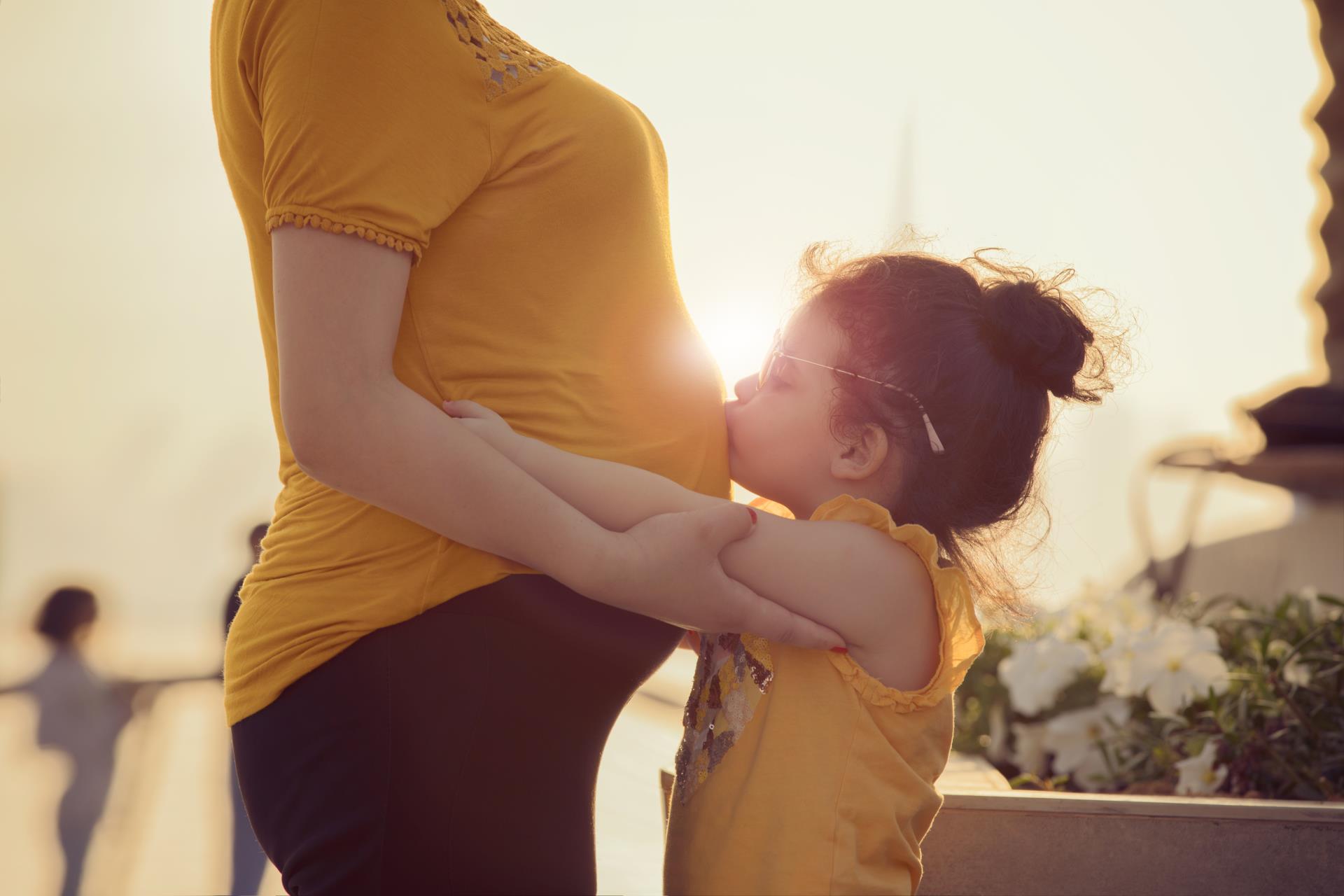 child kissing mom's stomach