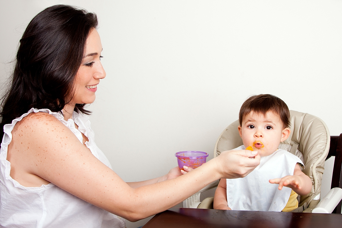 mother spoon feeding baby